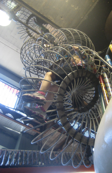 Kids crawling through metal spirals